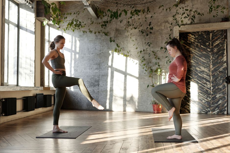 Sunlit yoga studio interior with plants and neatly stacked props