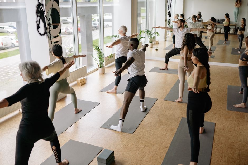 Students flowing through a vinyasa sequence in a sunlit studio