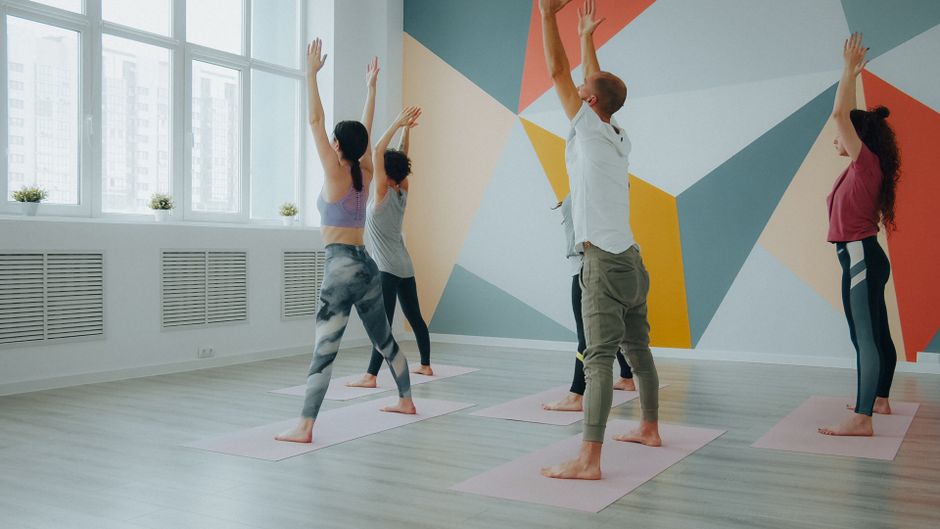 A teacher guiding a vinyasa flow pose
